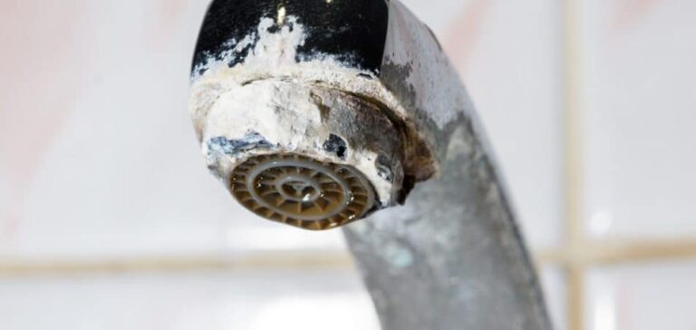 White hard water buildup on a bathroom faucet in a North Jersey home