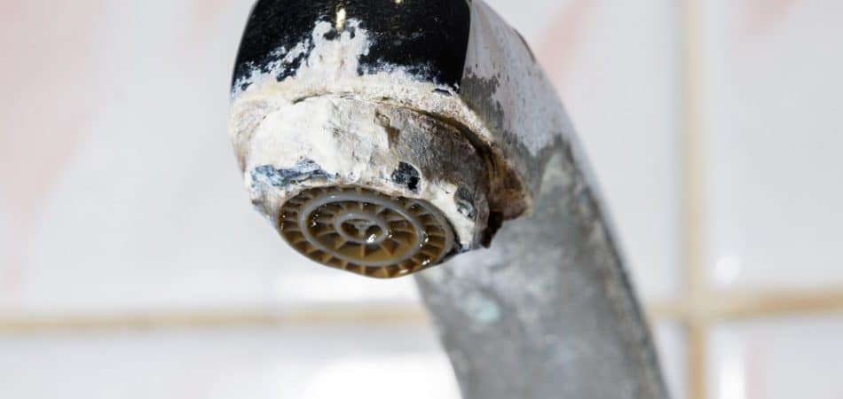 White hard water buildup on a bathroom faucet in a North Jersey home